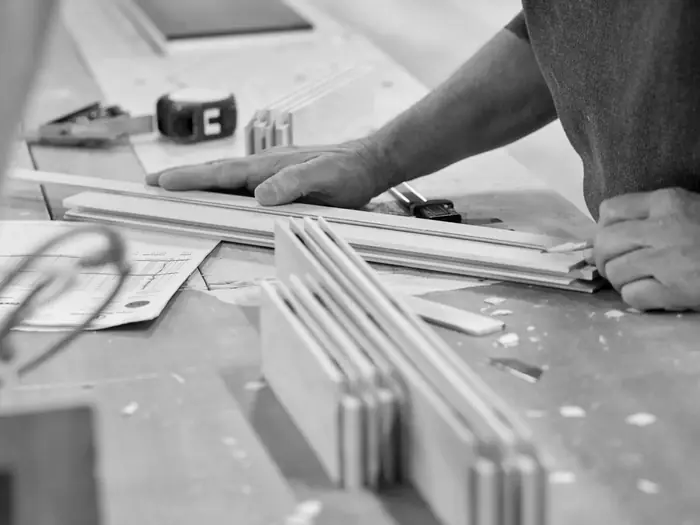 Rails and stiles laid out on the bench beside a shop drawing