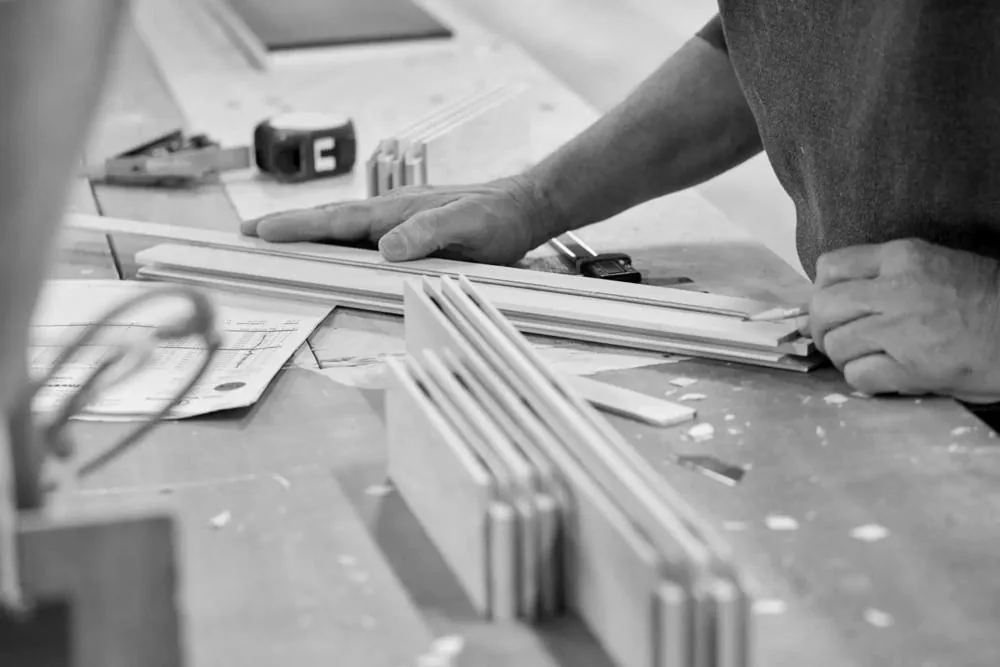 Rails and stiles laid out on the bench beside a shop drawing