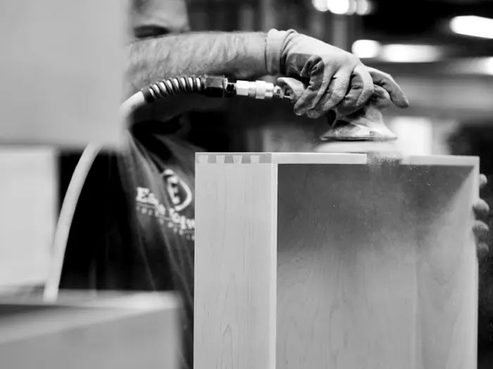 Dovetail drawer box being sanded on the shop floor
