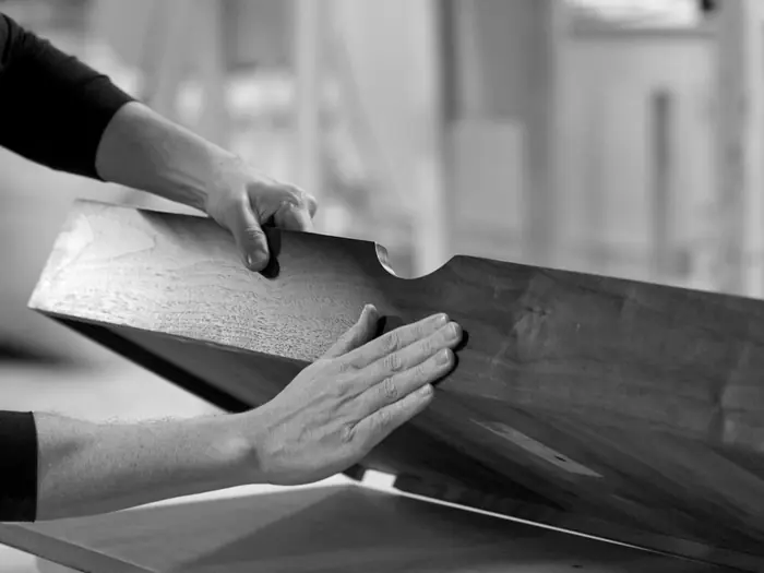 Two hands guide a finished walnut drawer box